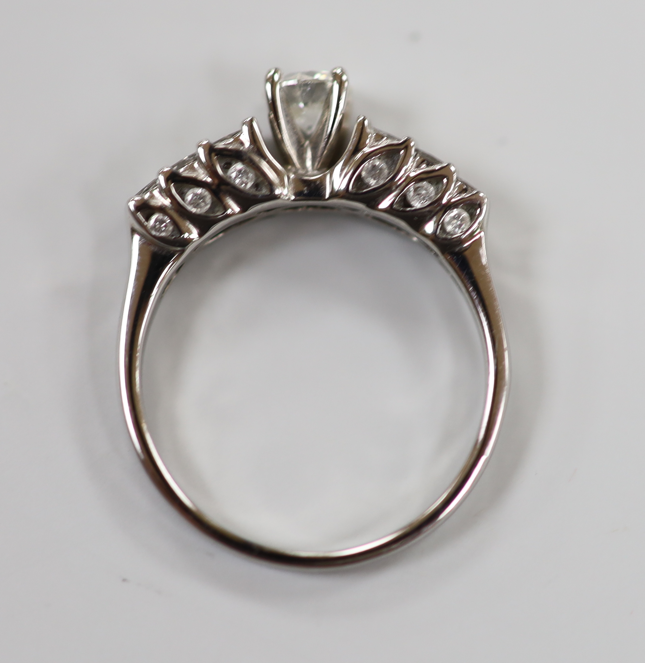 A modern 18ct white gold and single stone diamond ring, with three row graduated diamond set shoulders, size N, gross weight 4.2 grams.